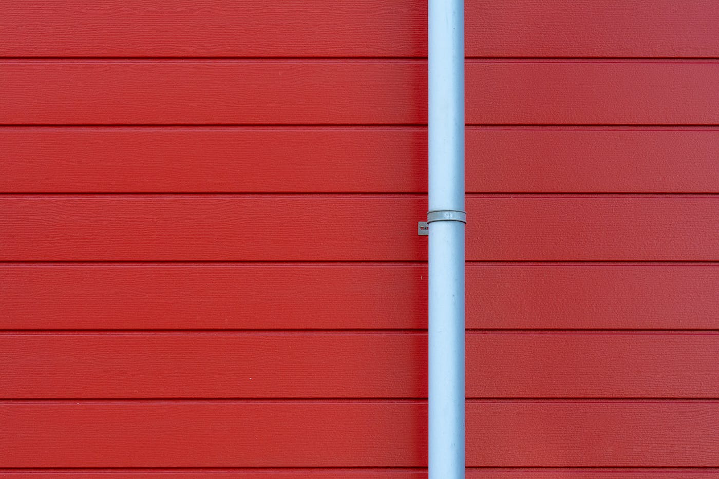 Rain gutter and downspout on a building wall showing the drainage system connection
