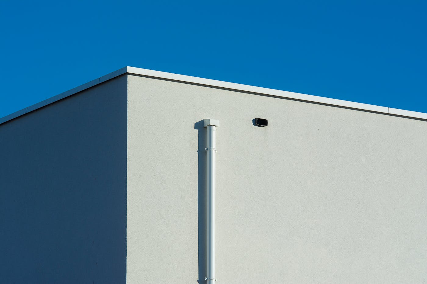 Gutter on sunlit building showing clean drainage system ready for inspection