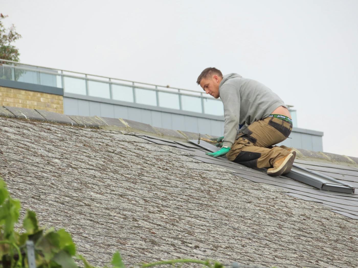 Handyman on a rooftop performing repair work, similar to gutter repair in Passaic NJ